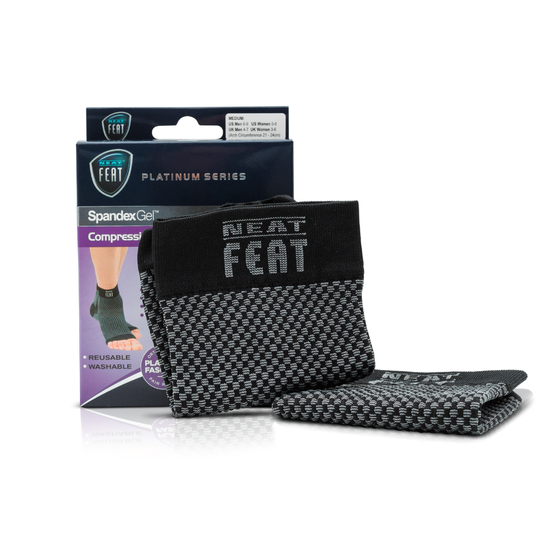 Platinum Series Spandex Gel Compression Arch Sock. The image shows the product box alongside the sock resting against it. The sock is black and grey, while the box is mostly dark blue and purple. The front of the box features an image of a foot demonstrating the fit of the sock, highlighting its arch support benefits.